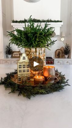 a vase filled with plants and candles on top of a table