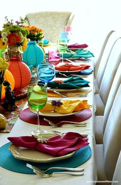 the table is set with colorful plates and place settings