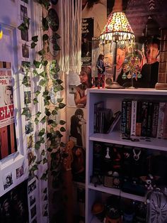 a room with bookshelves, plants and pictures on the wall next to it