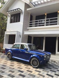 a blue and white car parked in front of a house