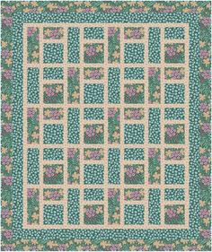 a green and pink quilt with flowers on the border, in front of a white background