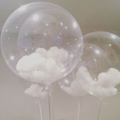 three clear balloons with white clouds on them