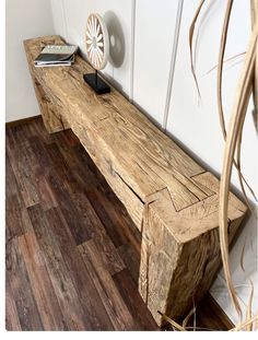 a wooden bench sitting on top of a hard wood floor next to a planter