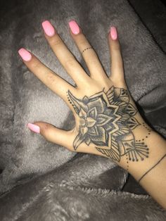 a woman's hand with a tattoo on it and pink nail polish vares