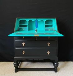 a black and blue desk with two drawers on one side and an open drawer on the other