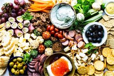 an assortment of food including crackers, olives and cheese