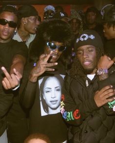 two young men standing next to each other in front of a group of people wearing sunglasses