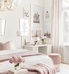 a white bedroom with pink accents and pictures on the wall