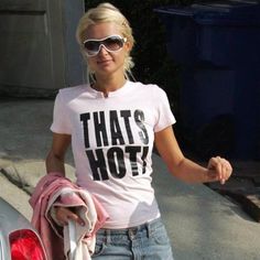 a blonde woman wearing sunglasses and a t - shirt with that's hot written on it