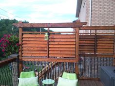 two green chairs sitting on top of a wooden deck