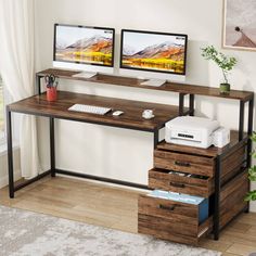 two computer monitors sitting on top of a wooden desk