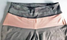 a close up of a person's shorts on a white surface with a black and pink stripe