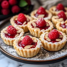 raspberry tarts with almonds on a plate