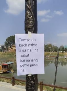 a sign attached to a pole near a body of water