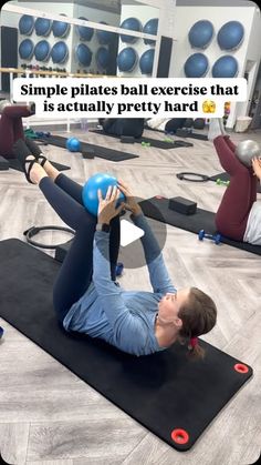 a woman is doing pilates exercises on a mat in the middle of a gym