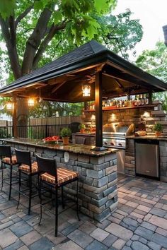 an outdoor kitchen with grill and seating area