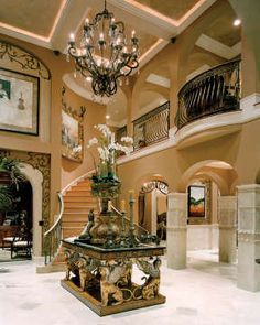 an elegant foyer with chandelier and marble steps leading up to the second floor