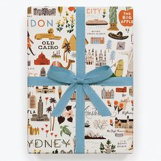 a wrapped gift box with a blue ribbon on it and an image of the city