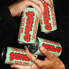 two hands holding three cans of chewing gum