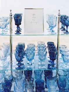 blue glass vases and glasses are on display