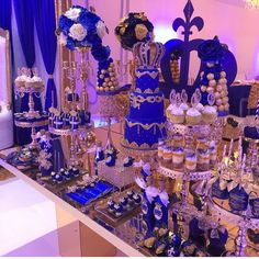 a table topped with lots of blue and gold desserts