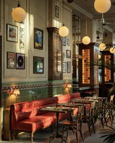 a restaurant with tables, chairs and pictures on the wall