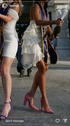 two women in dresses walking down the street