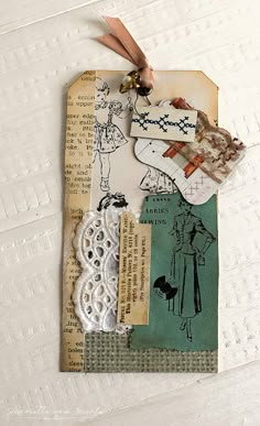 an altered piece of paper with lace and tags