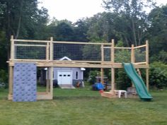 a wooden structure with a slide in the yard