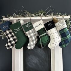 christmas stockings hanging from a mantel decorated with greenery and dog bone on them