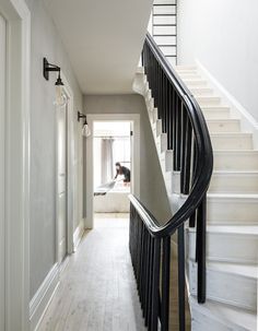 a long white staircase with black railing and handrails leading up to the second floor