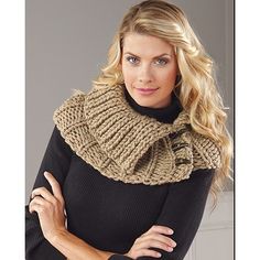 a woman wearing a knitted cowl neck scarf and black turtle - neck sweater