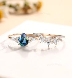 two rings with blue and white diamonds on them sitting on a table next to each other