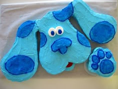 a cake shaped like a dog with blue icing