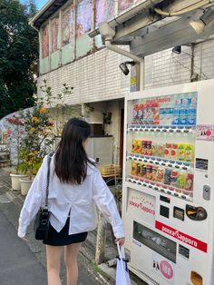 a woman is walking past a vending machine