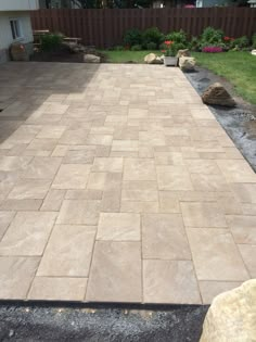 a patio with stone pavers and landscaping in the background