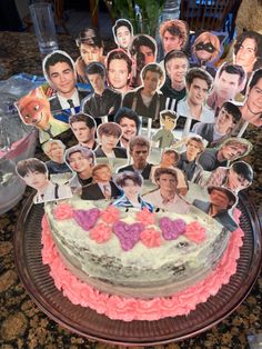 a birthday cake with many pictures of people on it and candles in the shape of hearts