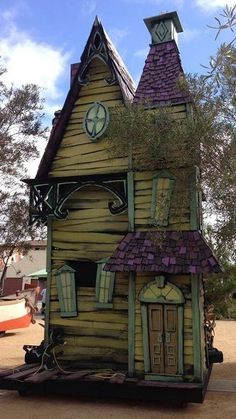 a wooden house made to look like it is in the shape of a dollhouse