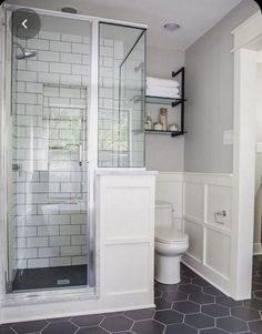 a bathroom with white walls and black flooring