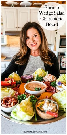 a woman sitting at a table full of food with the words shrimp wedge salad charcuterie board