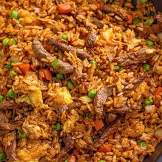 beef fried rice in a skillet with peas and carrots