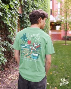 a young man standing in front of a lush green tree covered yard wearing a t - shirt that says summer is happy holidays