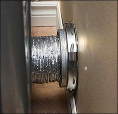 a close up of a wire spool on the side of a wall with a door open