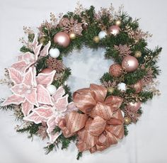 a christmas wreath with pink and gold decorations