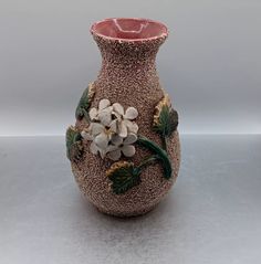 a vase with flowers and leaves painted on it