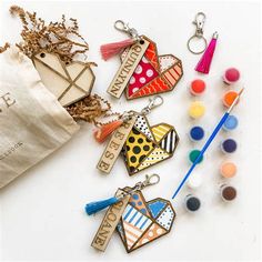 several keychains with different designs and colors on them next to some crafting supplies