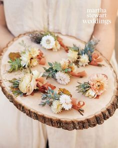 a person holding a piece of wood with flowers on it and the words martha stewart weddingss