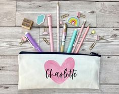 a pencil case with the word juicy written on it and various stationery items around it