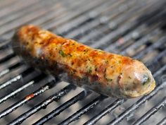 a sausage is cooking on the grill with it's end covered in seasoning