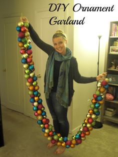 a woman is holding up an ornament made out of balls and beads in the shape of a heart